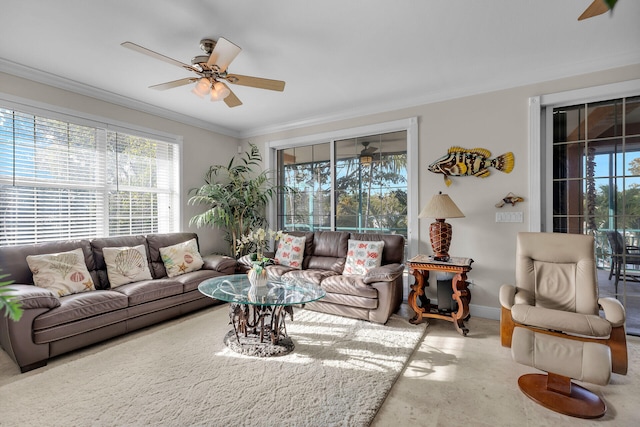 living area with ceiling fan, baseboards, and crown molding