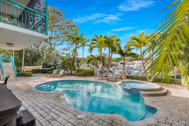 view of pool with a pool with connected hot tub and a patio