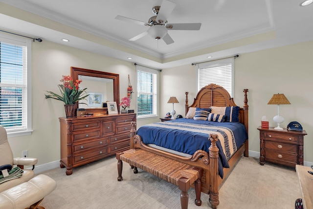 bedroom featuring ornamental molding, a tray ceiling, light colored carpet, and baseboards