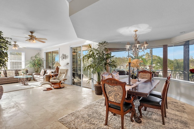 dining area featuring baseboards, ceiling fan with notable chandelier, and crown molding