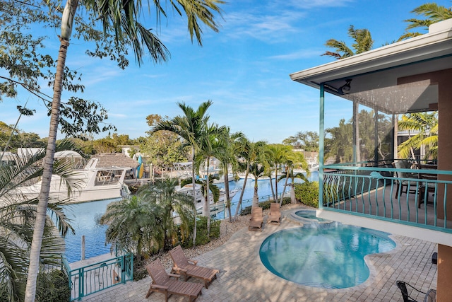 view of pool featuring an in ground hot tub and a water view