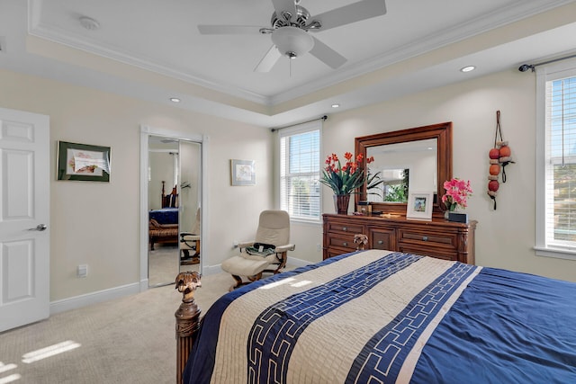 carpeted bedroom with baseboards, a raised ceiling, and crown molding