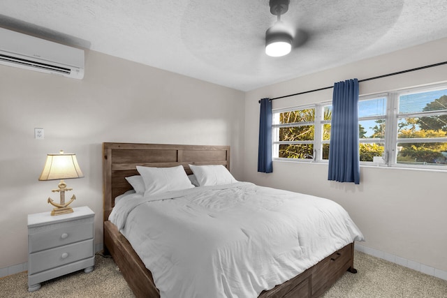 carpeted bedroom with a wall mounted air conditioner and a textured ceiling