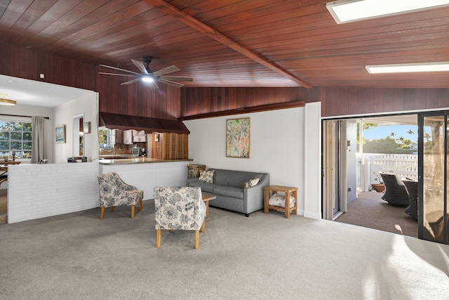 carpeted living room with wood ceiling, ceiling fan, lofted ceiling, and wooden walls