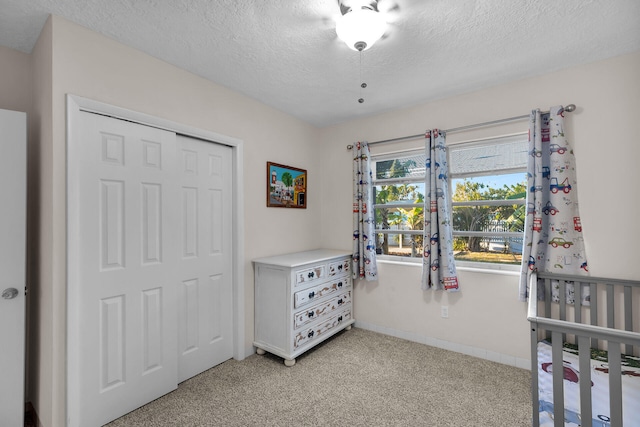 carpeted bedroom featuring a closet and a textured ceiling