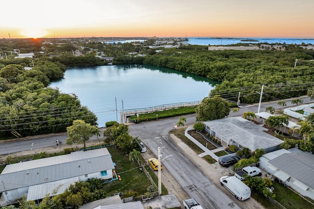 aerial view at dusk featuring a water view