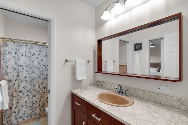 bathroom featuring vanity, toilet, and curtained shower