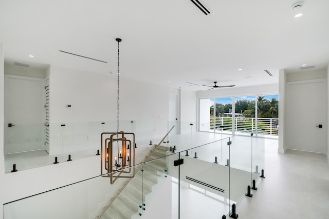 interior space featuring ceiling fan with notable chandelier