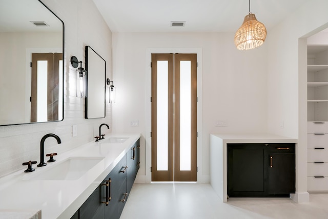 bathroom with built in features, vanity, and decorative backsplash