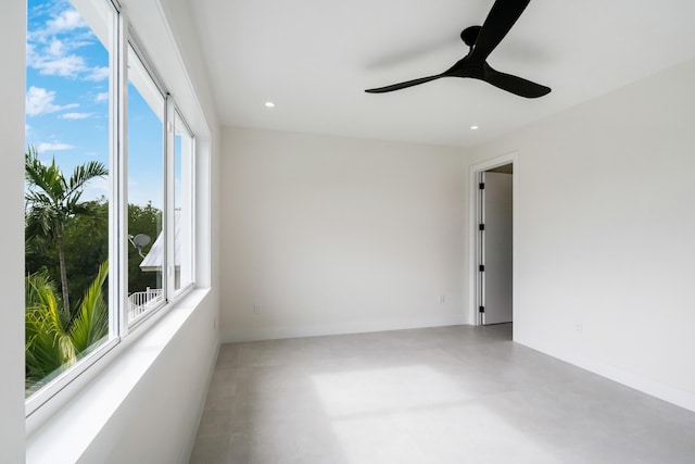 spare room featuring concrete floors and ceiling fan