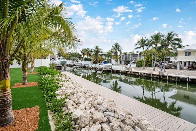 view of dock with a lawn and a water view