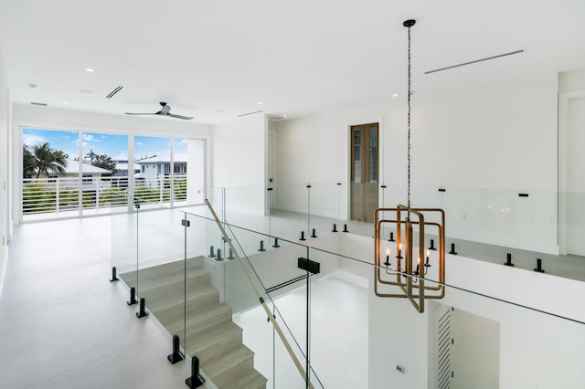 stairway featuring ceiling fan