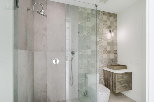 bathroom featuring vanity, tiled shower, tile walls, and toilet