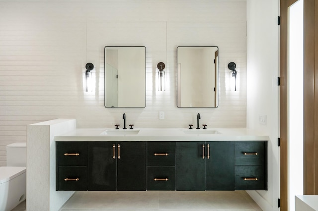 bathroom with vanity, toilet, and tile walls