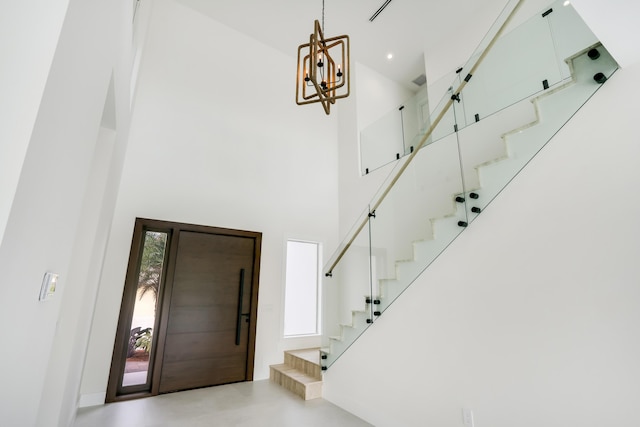 foyer featuring a towering ceiling and a notable chandelier