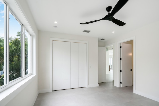 unfurnished bedroom with ceiling fan and a closet