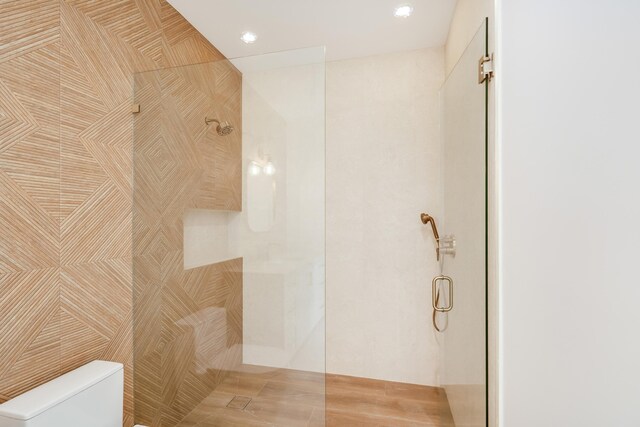 bathroom with toilet and a shower with shower door