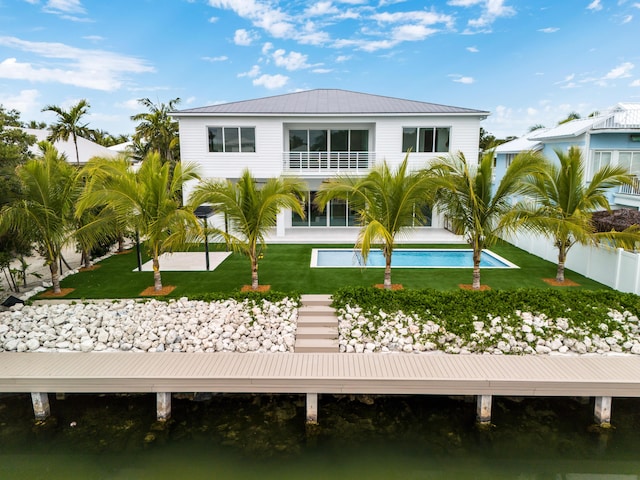 back of property featuring a water view and a yard