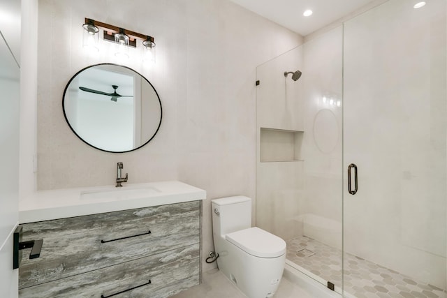 bathroom featuring a shower with door, vanity, and toilet