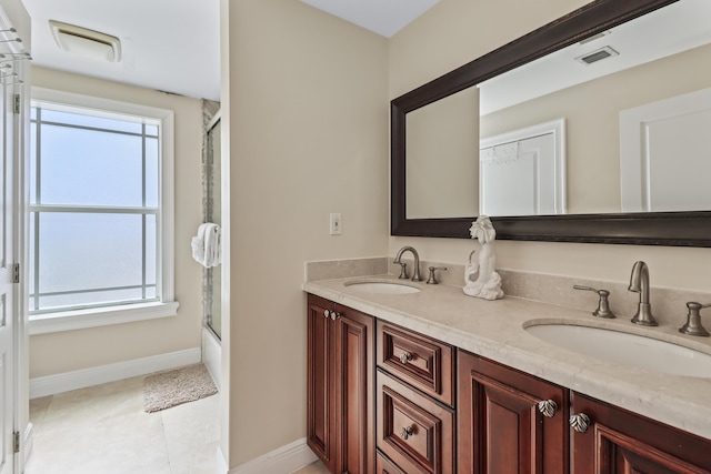 bathroom with a sink, visible vents, and double vanity