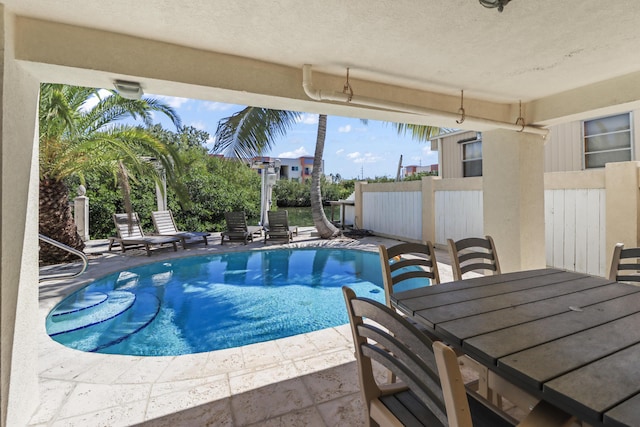 outdoor pool with outdoor dining area, a patio area, and fence