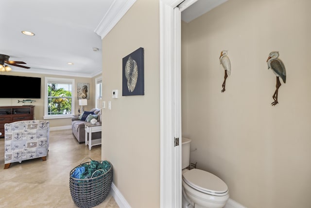 ensuite bathroom featuring baseboards, ornamental molding, ensuite bathroom, toilet, and ceiling fan