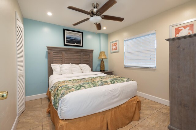 tiled bedroom featuring ceiling fan and a closet