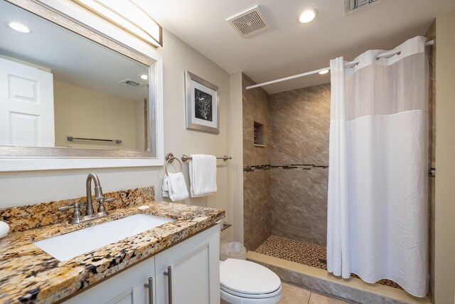 bathroom with a shower with curtain, vanity, toilet, and tile patterned flooring