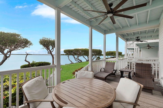 sunroom featuring beamed ceiling, a water view, and ceiling fan