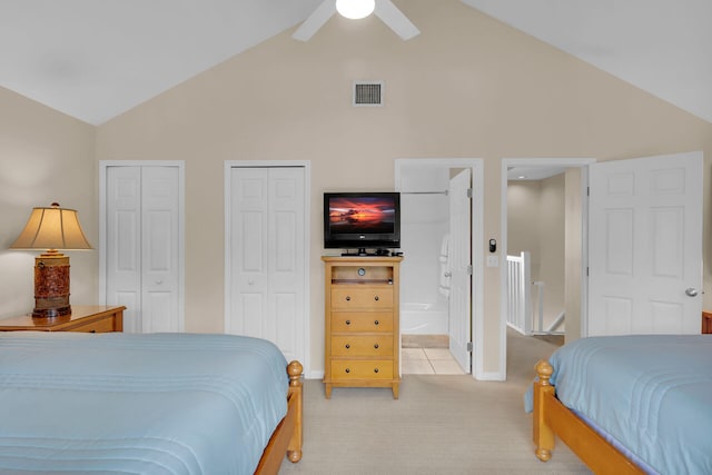 bedroom featuring ceiling fan, high vaulted ceiling, connected bathroom, light carpet, and multiple closets