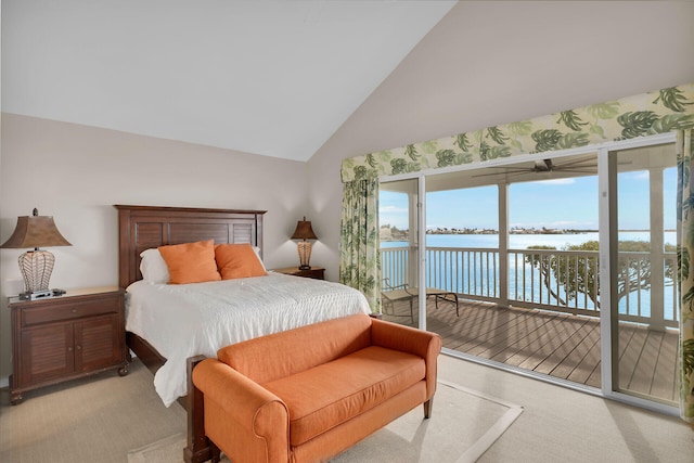 bedroom with a water view, light carpet, access to exterior, and high vaulted ceiling