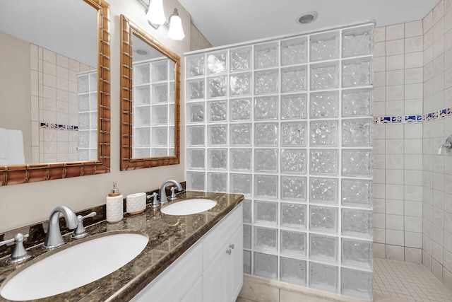 bathroom with vanity and a tile shower