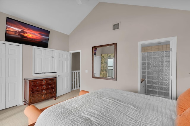 bedroom with two closets, high vaulted ceiling, and ensuite bathroom