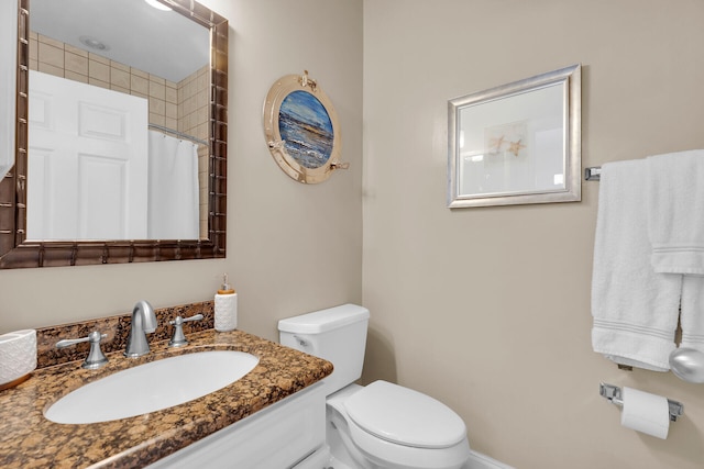 bathroom with vanity, a shower with shower curtain, and toilet