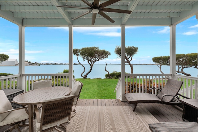 deck featuring a water view, ceiling fan, and a yard