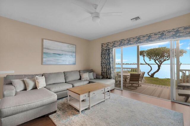 living room featuring a water view, ceiling fan, and wood-type flooring