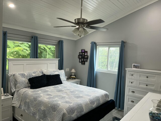 bedroom featuring light hardwood / wood-style flooring, wood ceiling, vaulted ceiling, and ceiling fan