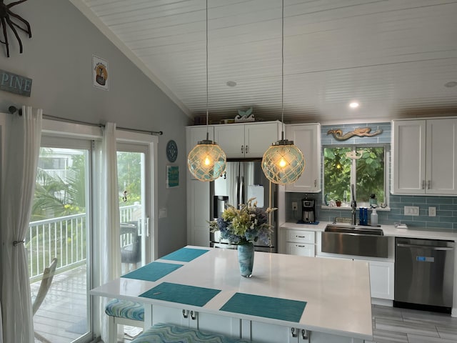 kitchen with sink, stainless steel appliances, tasteful backsplash, white cabinets, and vaulted ceiling