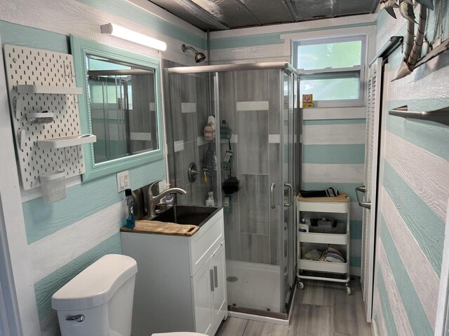 bathroom featuring an enclosed shower, vanity, wood-type flooring, and toilet