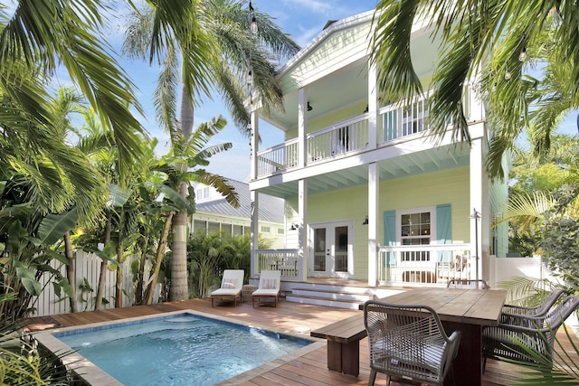 pool with outdoor dining space, french doors, and fence