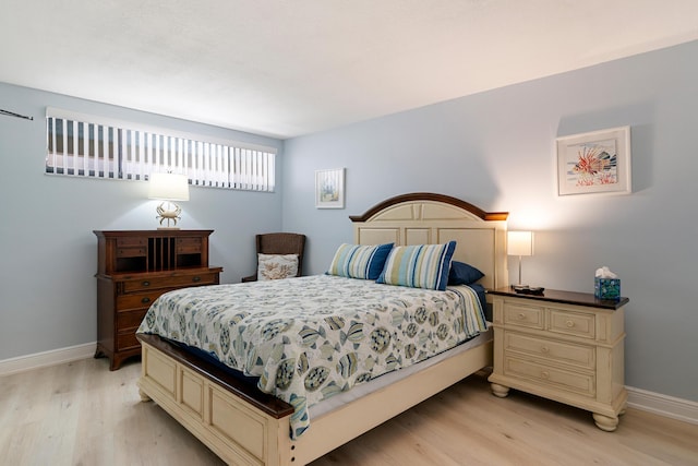 bedroom with light wood-type flooring and baseboards