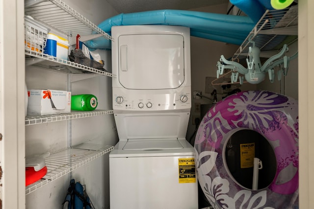 laundry area featuring stacked washing maching and dryer and laundry area