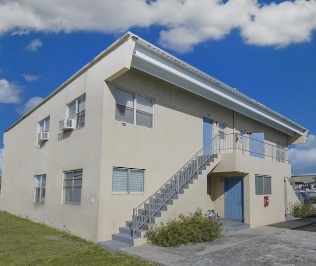 view of property with stairway and cooling unit