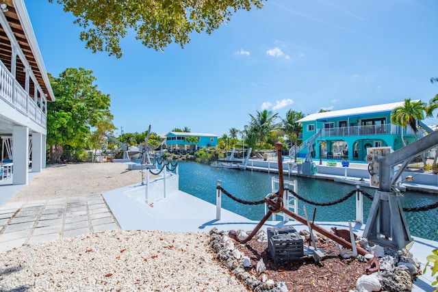 dock area with a water view and a balcony