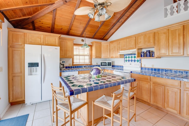 kitchen featuring under cabinet range hood, white appliances, wood ceiling, and tile counters