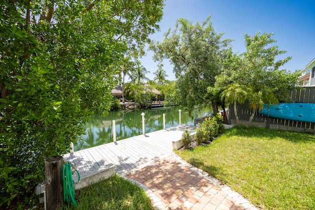 dock area with a water view and a lawn