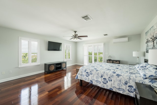 bedroom with dark hardwood / wood-style flooring, multiple windows, an AC wall unit, and ceiling fan