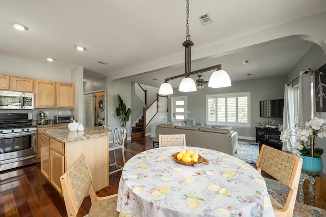 dining room featuring stacked washer and clothes dryer and dark hardwood / wood-style floors