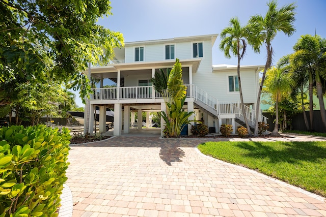 raised beach house with a carport and covered porch