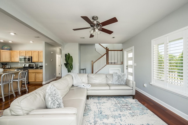 living room featuring dark wood-type flooring and ceiling fan